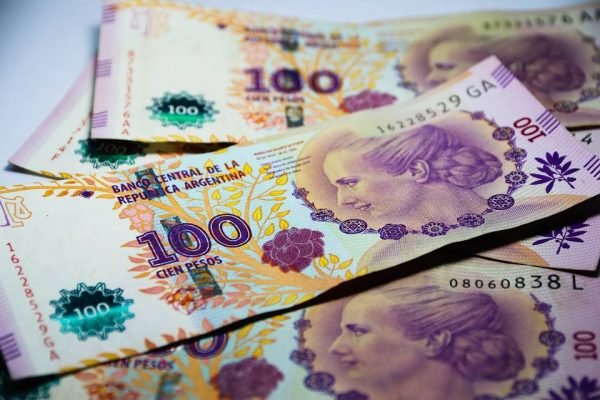 Imagem colorida de notas de cem pesos argentinos - Metrópoles