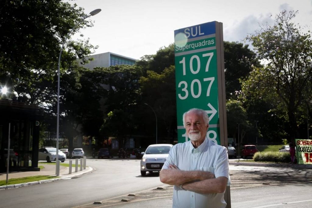 Idoso de costas para placa de sinalização