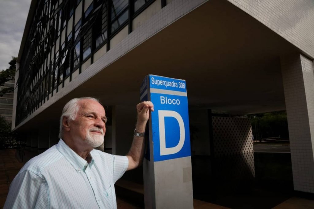 Homem apoia braço em placa