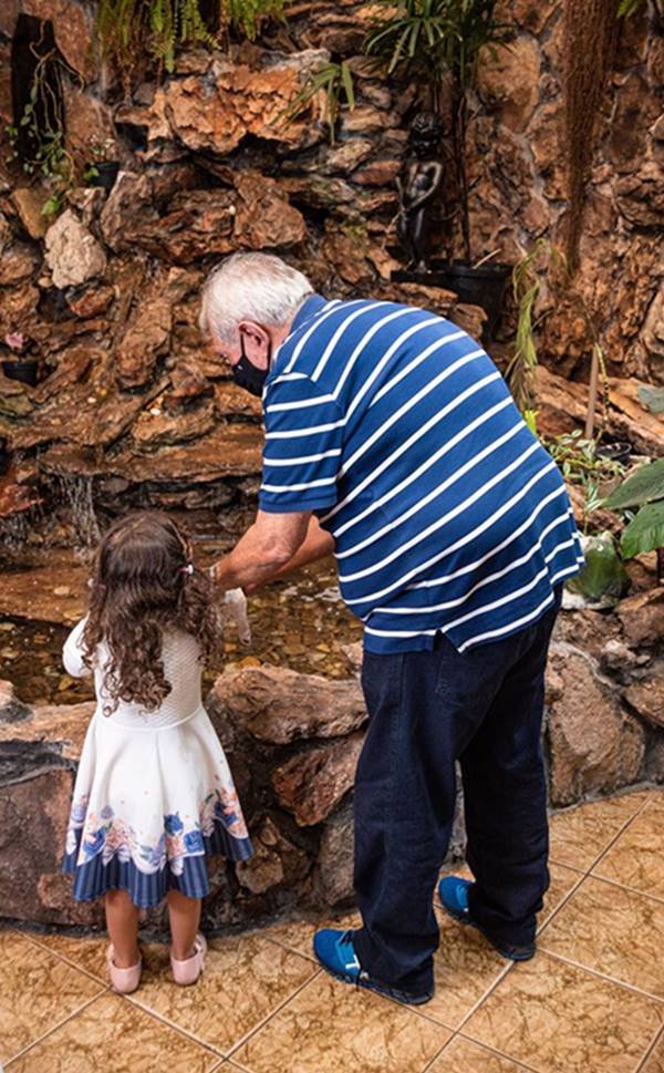 foto de idoso e criança em frente a uma fonte