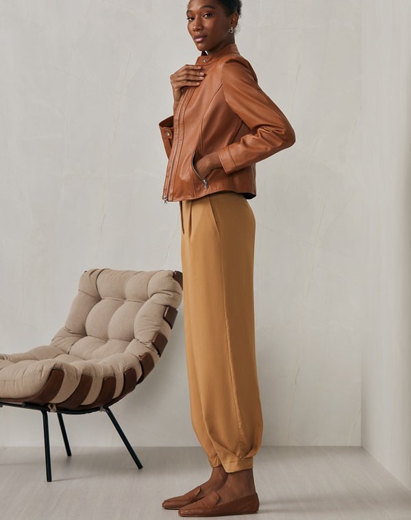 Na imagem, modelo usa casaco de couro marro com calça da mesma cor