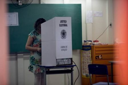 Fotografia colorida de mulher em cabine de votação