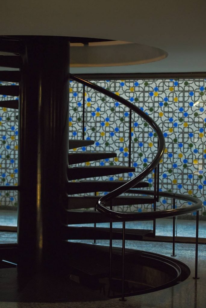 Escada em espiral e azulejos coloridos ao fundo