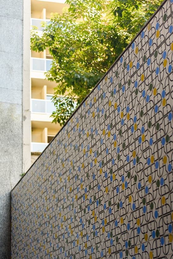 Azulejos em muro e folhas verdes em cima
