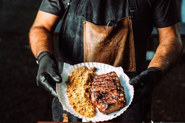 Na foto, um prato de comida com carne e farofa - Metrópoles