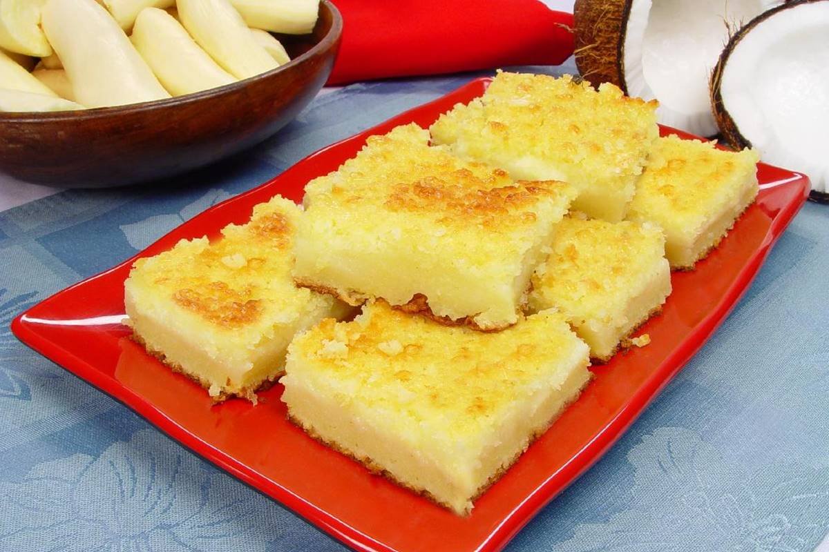 foto de travessa vermelha com pedaços quadrados de bolo de mandioca