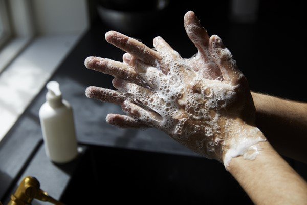 Pessoa lavando as mãos com sabão - Metrópoles