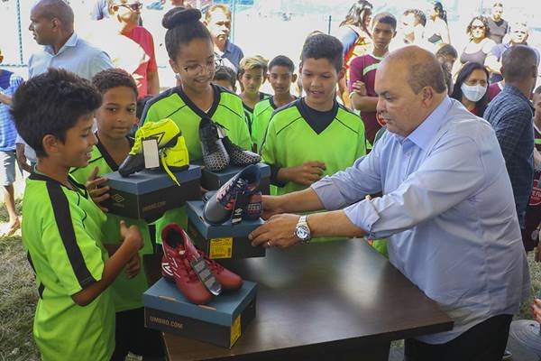 Fotografia colorida de crianças recebendo chuteiras