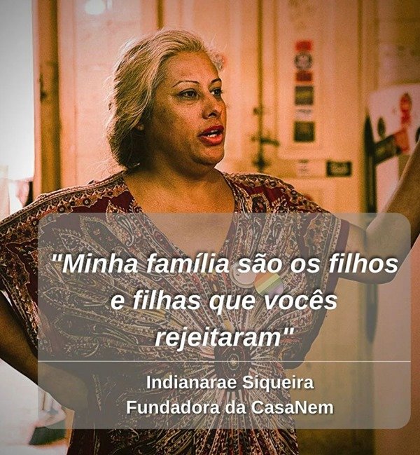 mulher trans fala enquanto é fotografada. uma frase pode ser lida na foto