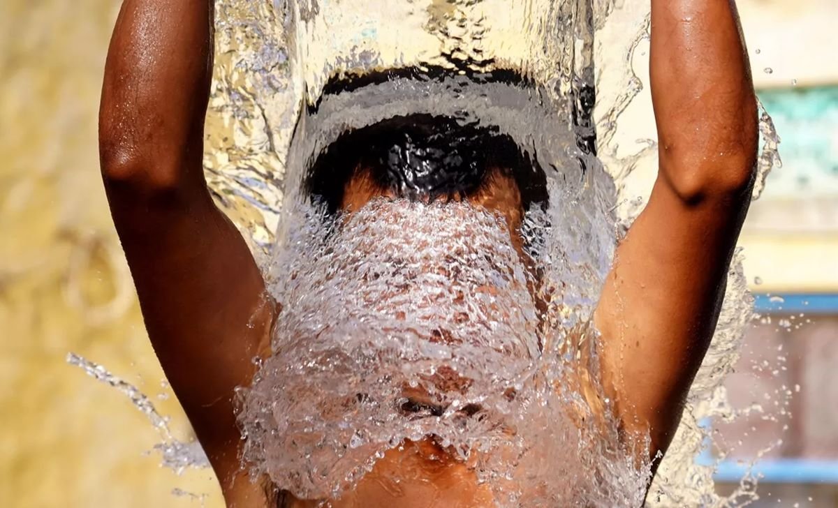 menino negro se banha com água de balde