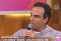 O apresentador do BBB22, Tadeu Schmidt, pede desculpas a Renata Lo Prete no programa Encontro. Ele usa moltem cinza e segura microfone na mão - Metrópoles