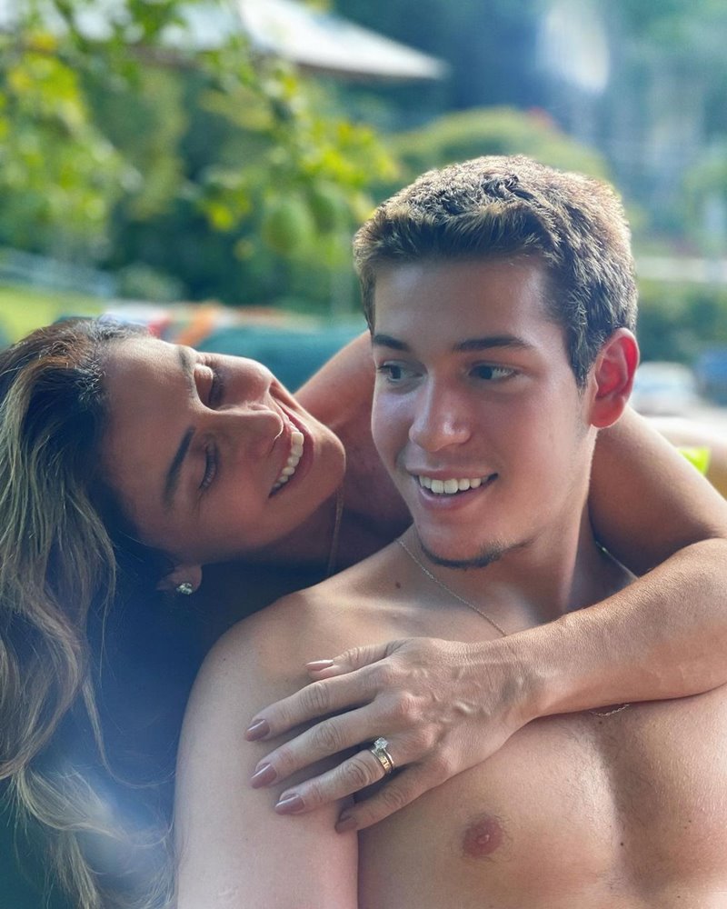 A atriz Giovanna Antonelli e o Pietro, seu filho com o ator Murilio Benício. Eles estão sentados na beira da piscina.