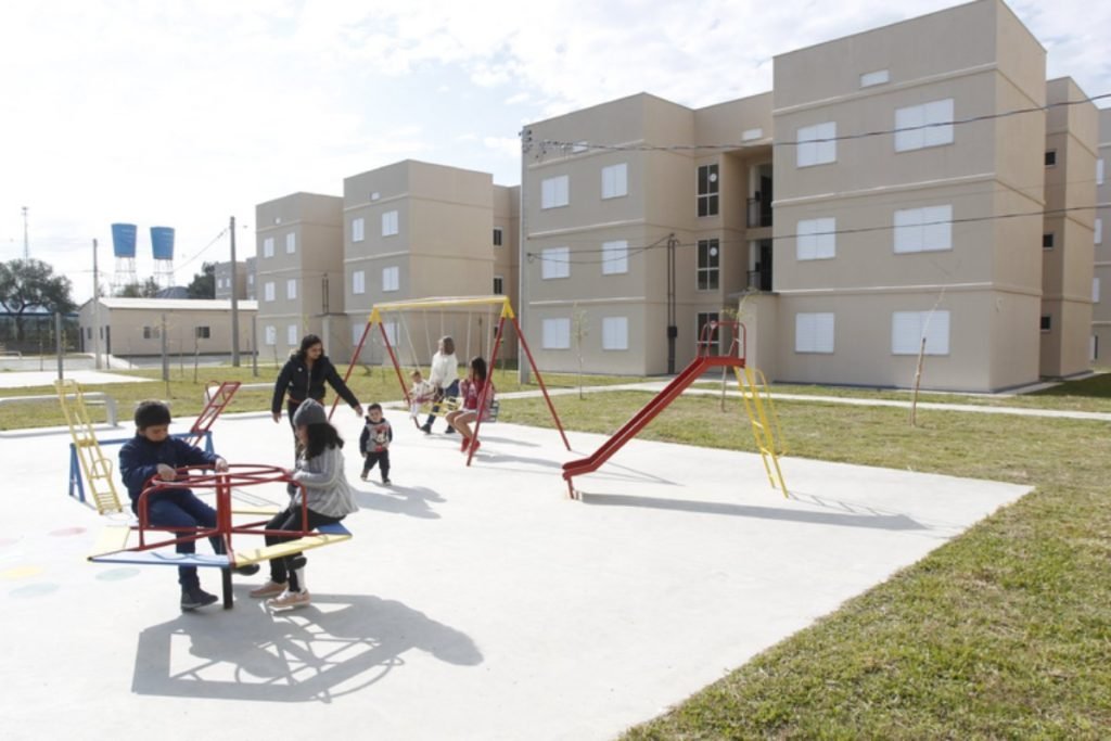 Crianças brincando em parque em frente à setor habitacional