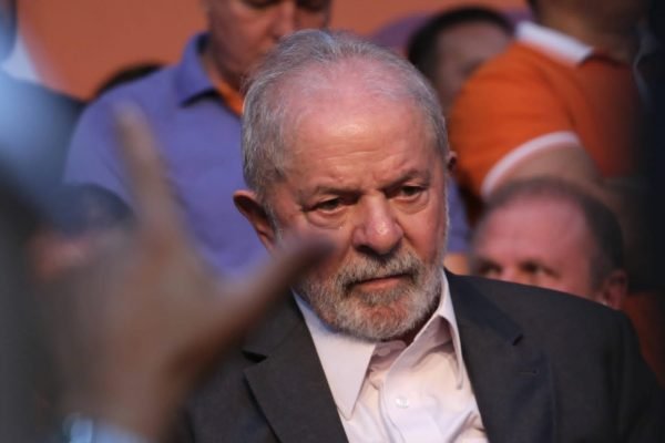 O ex-presidente Lula em evento, cercado de outras pessoas. Ele usa terno e tem expressão sério - Metrópoles