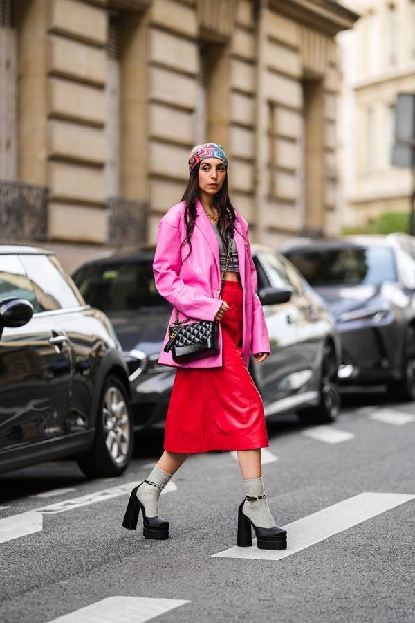 Look no street style com plataforma preta, saia midi vermelha e blazer rosa 