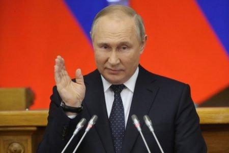 Presidente russo Vladimir Putin em pulpito com microfones
