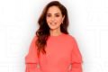 A dermatologista Adriana Vilarinho sorrindo para foto. Ela usa blusa de manga longa rosa - Metrópoles