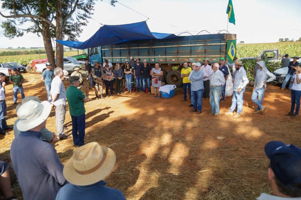 pessoas ao lado de bandeira do Brasil estendida