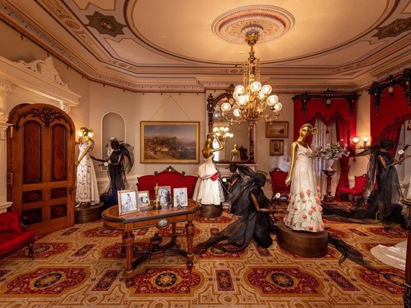 Sala com decoração e móveis do século 18 e manequins vestindo roupas de época. A sala faz parte da exposição In America: An Anthology of Fashion, em cartaz no Metropolitan Museum of Art, em Nova York
