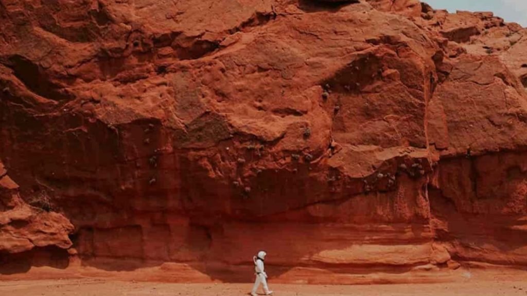 ilustração de uma possível paisagem em Marte com um astronauta andando sobre as pedras