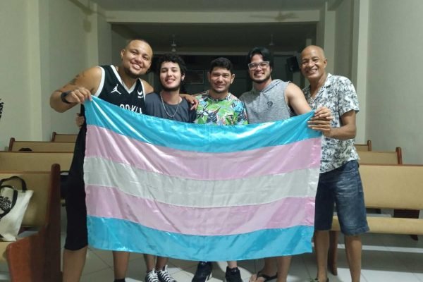 Participantes de projeto voltado a homens trans com bandeira da causa Trans