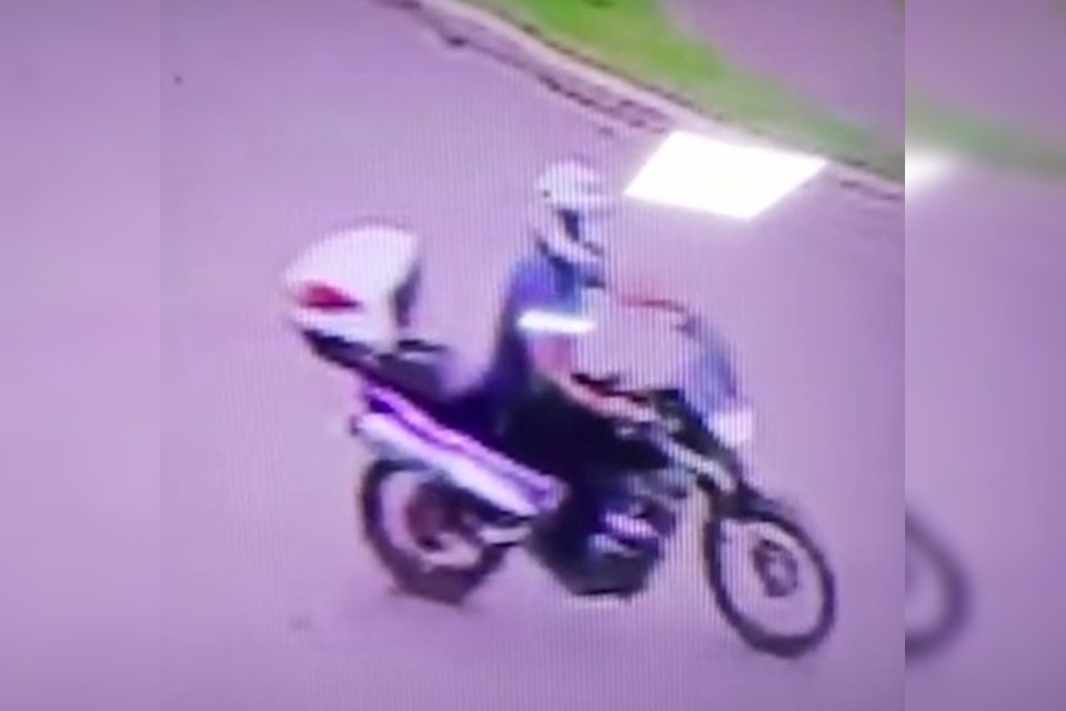 Homem de capacete em moto na pista