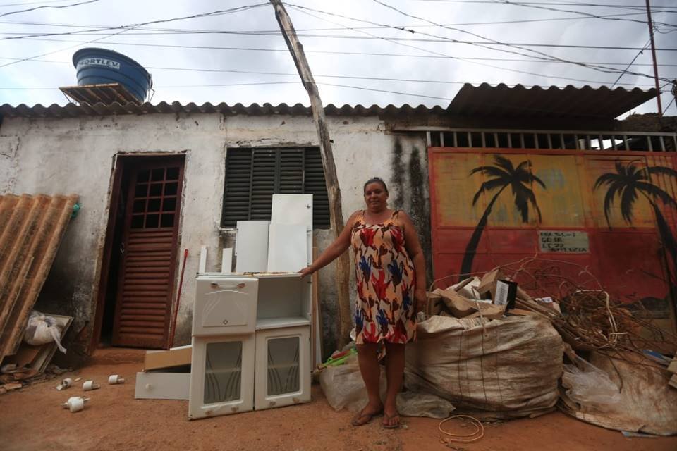 Mulher em frente de material recolhido para reciclagem - Metrópoles