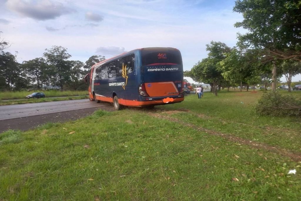 Ônibus azul com laranja em canteiro de rodovia