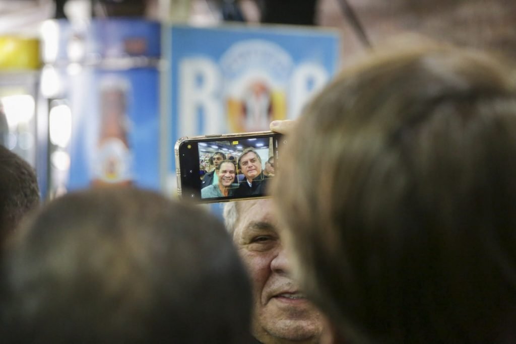 alberto fraga aobserva o presidente jair bolsonaro tirando foto com apoiadores