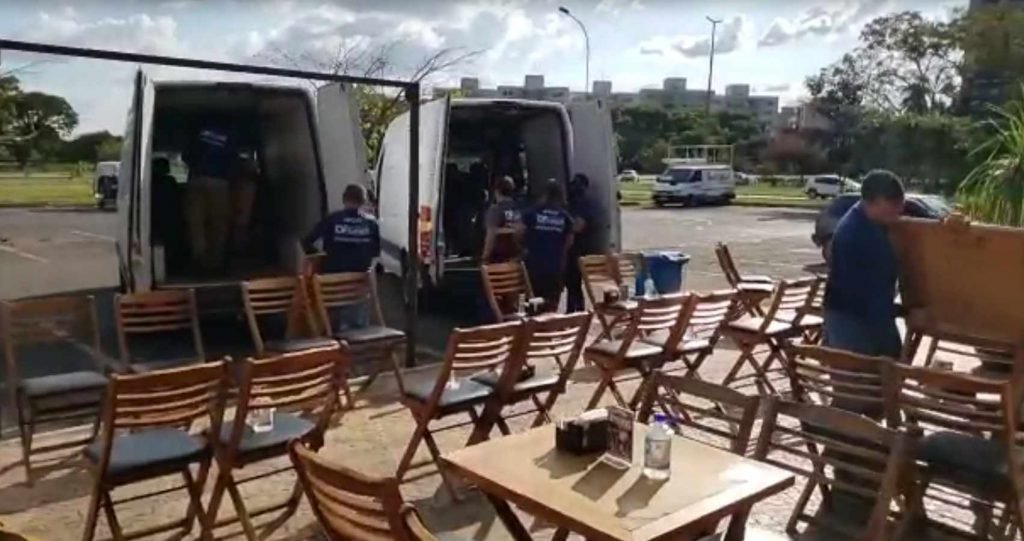 agentes do DF Legal colocando mesas e cadeiras em carro