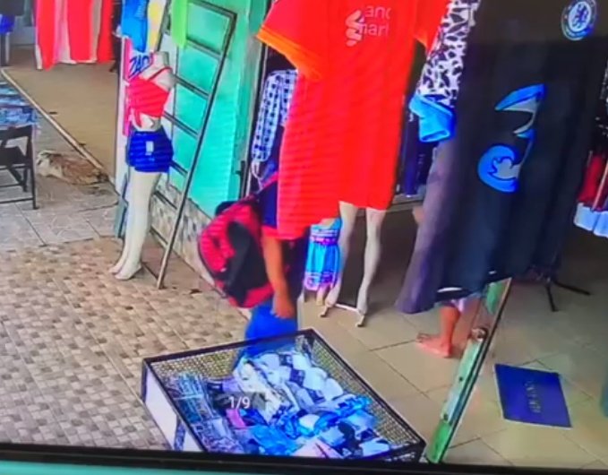 homem em pé com camisa cobrindo o rosto