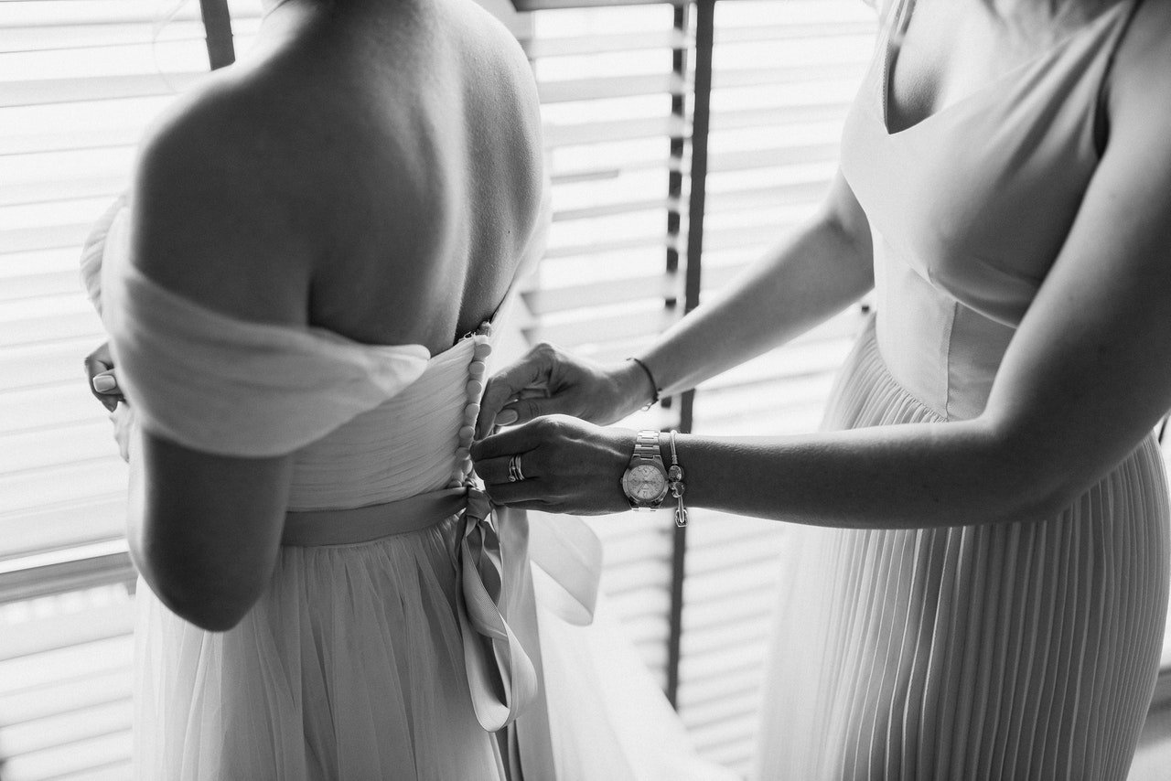 Mãos arrumando vestido de noiva