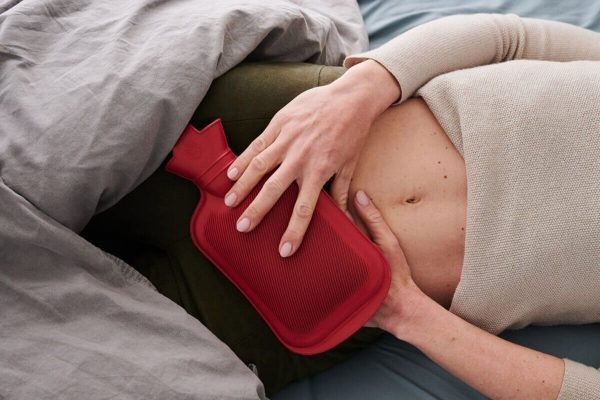 mulher com bolsa térmica no útero
