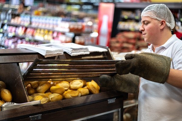padeiro coloca pães franceses dento de uma estufa