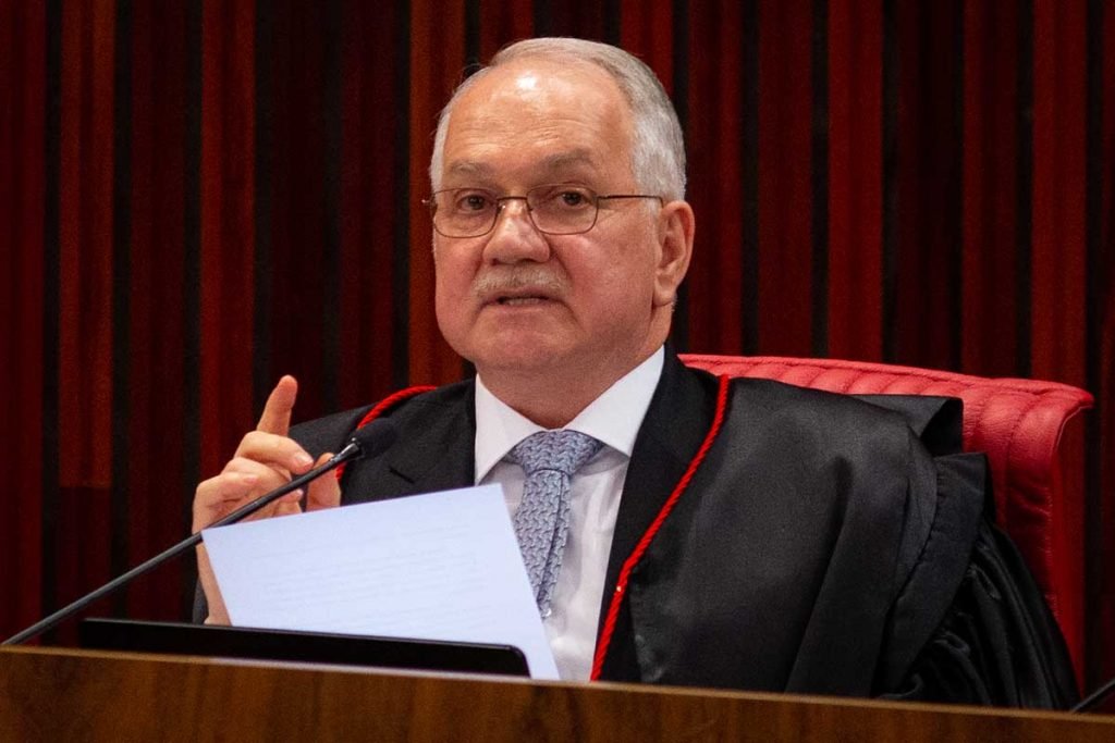O presidente do Tribunal Superior Eleitoral, ministro Edson Fachin, lê um discurso com um papel na mão e gesticulando - Metrópoles
