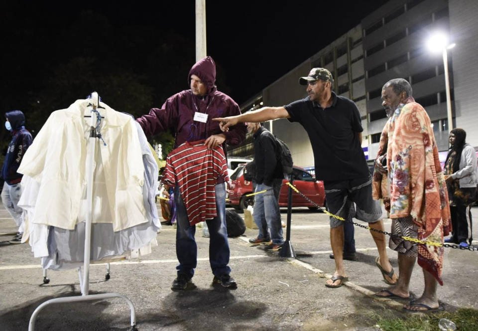 homem apontado para roupas
