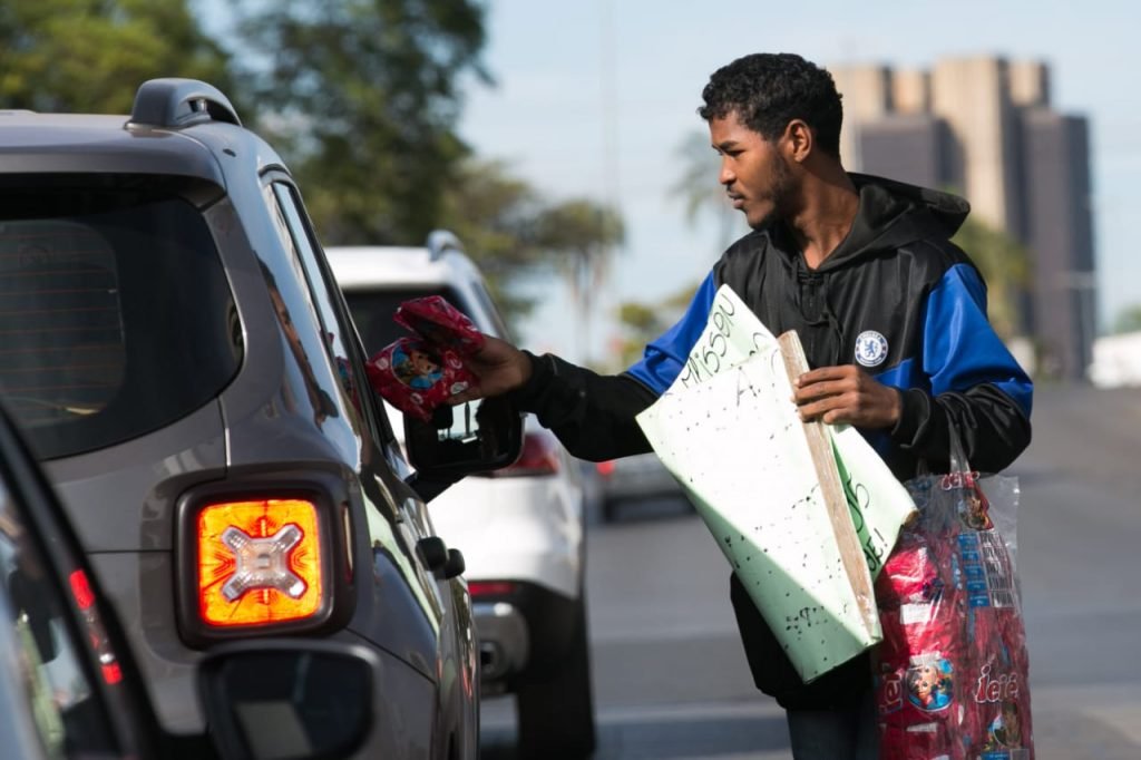 Homem vendendo pipoca no semáforo