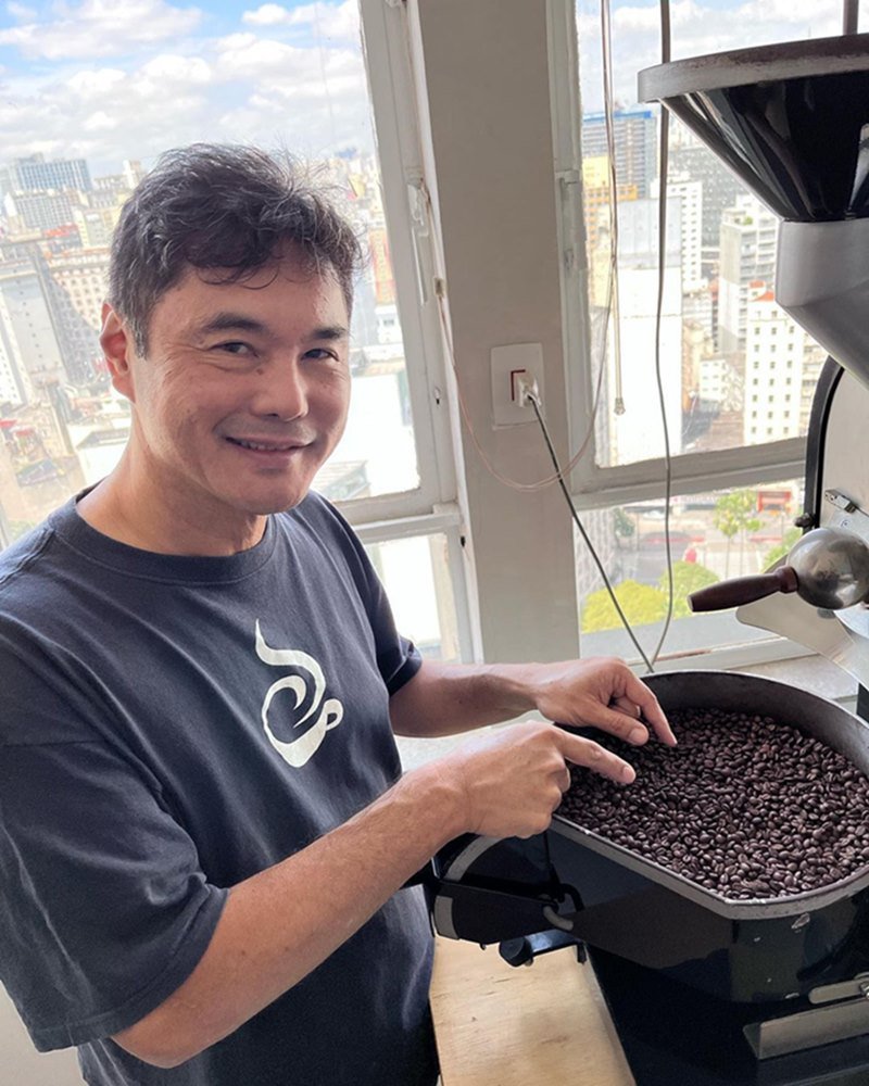 foto de homem com ascendencia oriental olhando graos de café