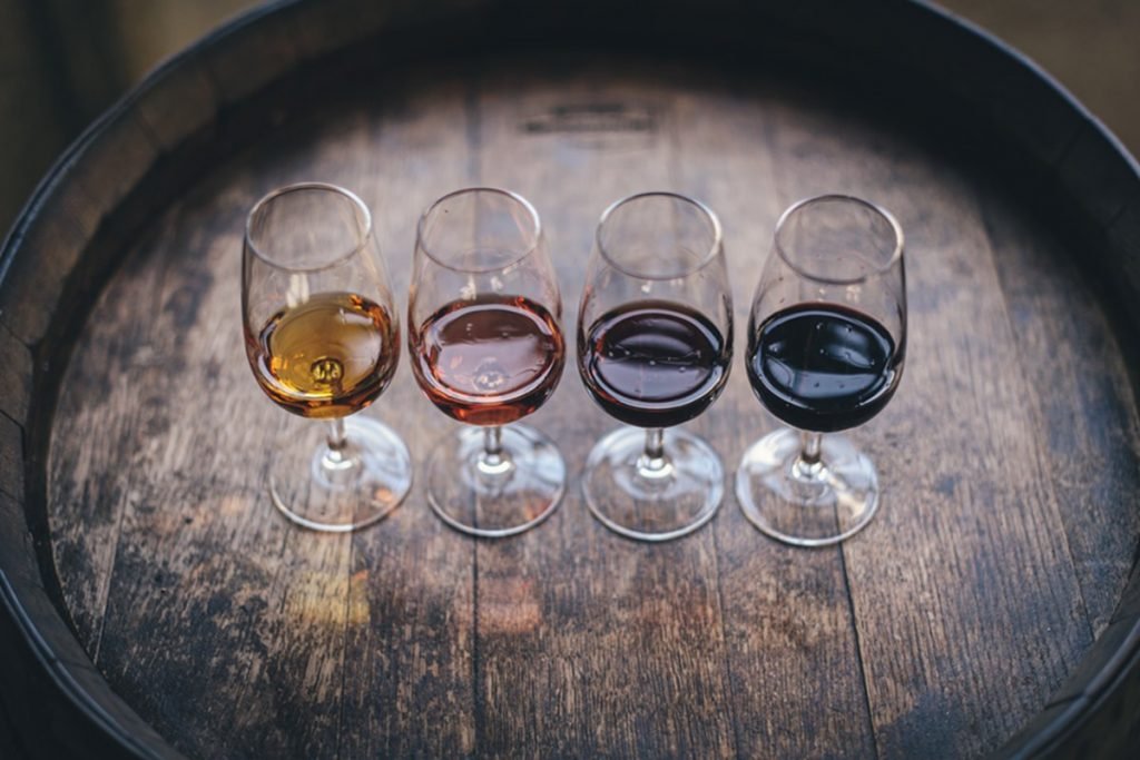 foto de barril com quatro taças e vinhos de cores diferentes dentro