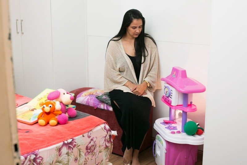 Claudete sentada com brinquedos em volta