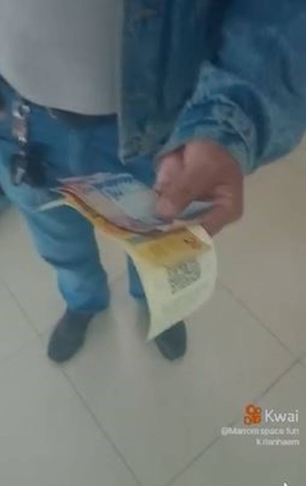 La fotografia a colori mostra la mano dell'uomo con le banconote