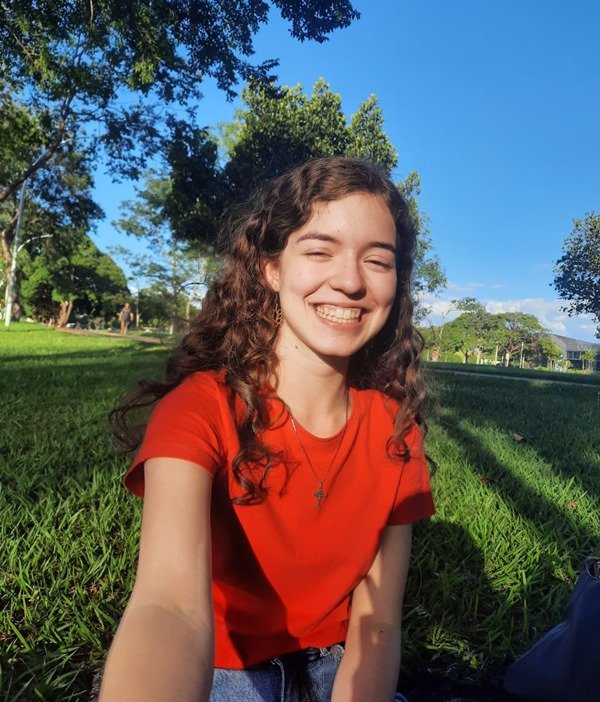 Foto de uma menina sorrindo com um fundo verde