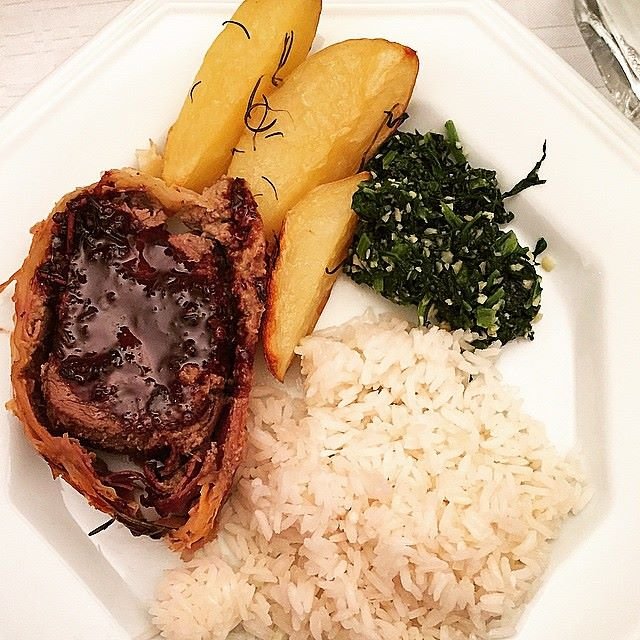 Imagem do bife Wellington servido com arroz, batatas e couve