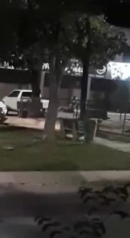 Homem camisa branca ataca outro homem, com fachada, em estacionamento de comércio