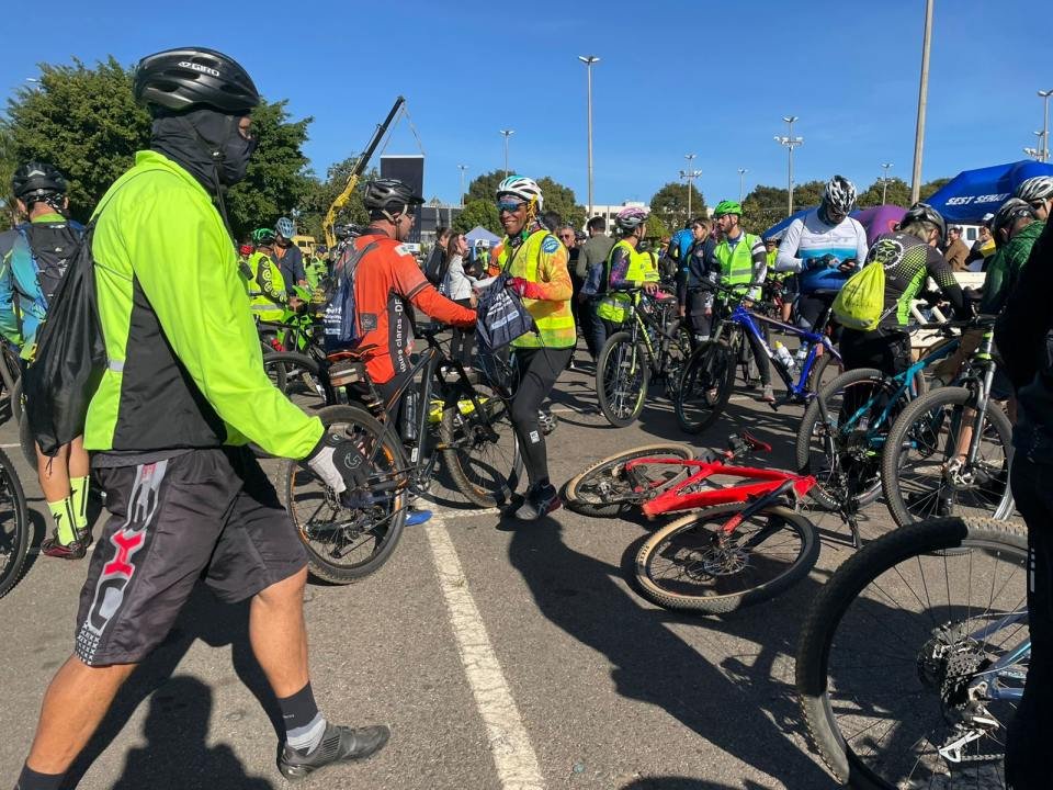 Ciclistas ao lado de bikes no estacionamento do Taguaparque