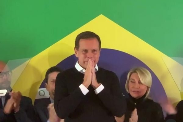 Imagem colorida mostra Joao Doria (PSDB), ex-governador de São Paulo, um homem branco, com cabelo grisalho, blusa preta e camisa branca por baixo, com as mãos juntas perto da boca, como se estivesse rezando - Metrópoles