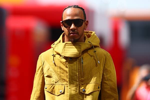 Lewis Hamilton usa jaqueta amarela com óculos escuros