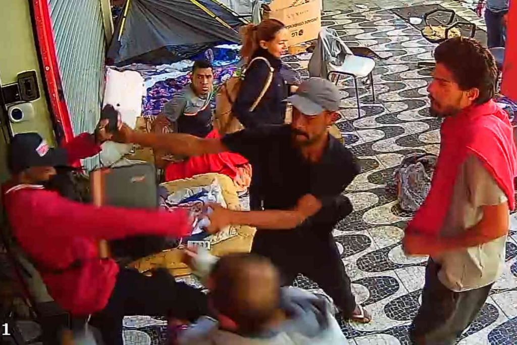 homem de casaco vermelho e de camisa preta com braços estendidos