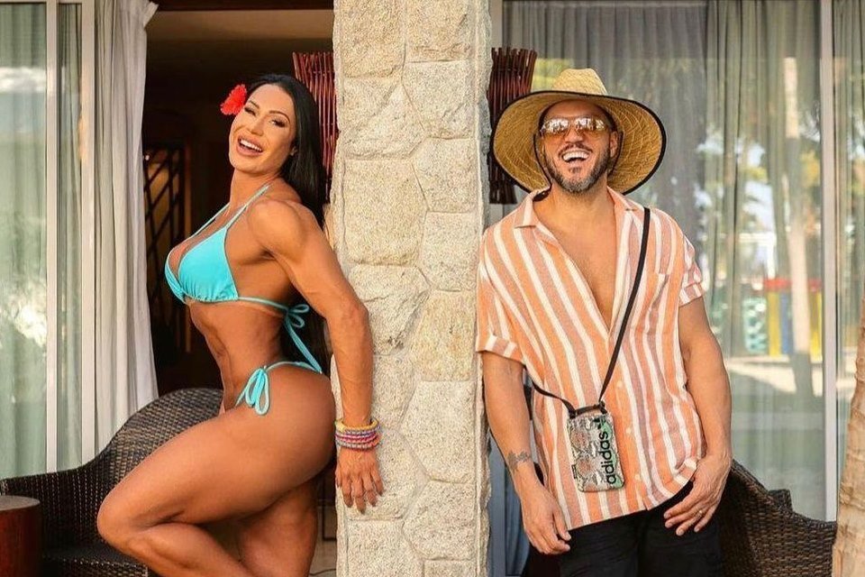 Gracyanne Barbosa e Belo posam sorridentes com roupas de praia - metrópoles