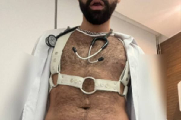 Médico que filma cenas de sexo com pacientes tira foto que mostra seu torso, sem mostrar o rosto, com o peito nu, colete de couro e estetoscópio - Metrópoles